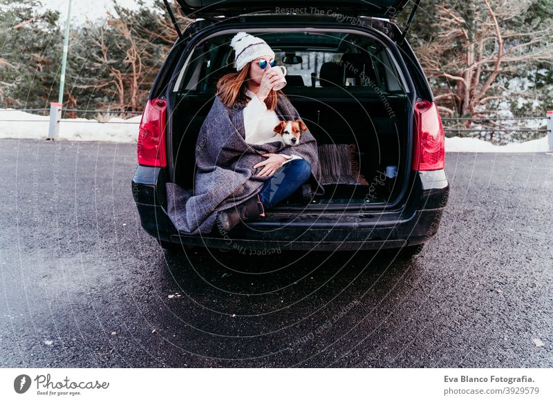 Junge Frau und niedlichen Jack Russel Hund im Auto. Wintersaison, verschneiten Berg Hintergrund Decke Natur Zusammensein Saison Fernweh Schönheit aktiv