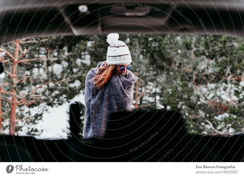 Rückenansicht aus dem Inneren eines Autos der jungen Frau im Freien trägt stilvolle Hut. Wintersaison. verschneiten Berg Hintergrund PKW Berge u. Gebirge