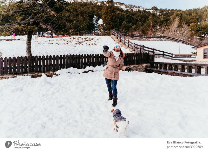 Frau und niedlichen Jack Russell Hund genießen draußen am Berg mit Schnee. Wintersaison Berge u. Gebirge im Freien reisen Lifestyle Fernweh reisend Spaß kalt