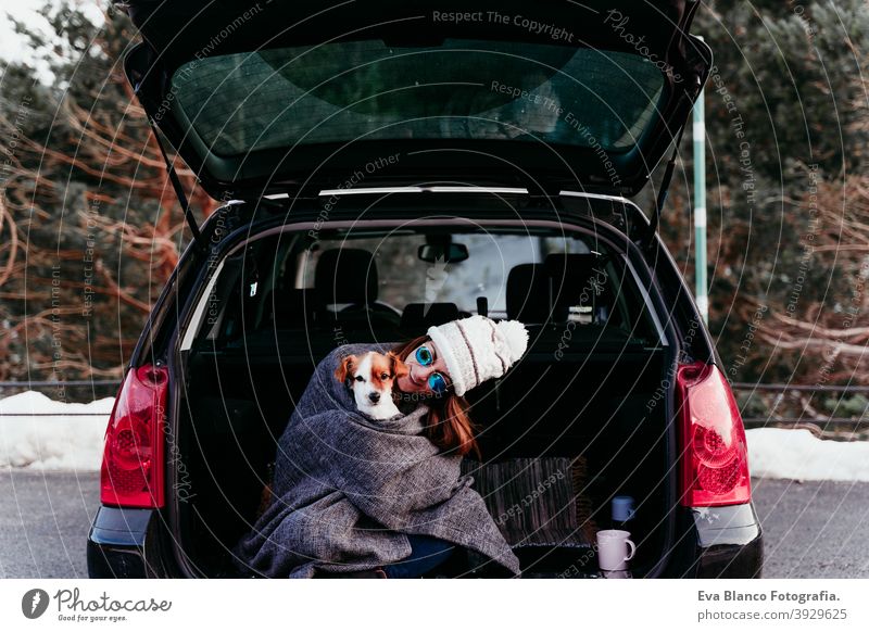 Junge Frau und niedlichen Jack Russel Hund im Auto. Wintersaison, verschneiten Berg Hintergrund Decke Natur Zusammensein Saison Fernweh Schönheit aktiv