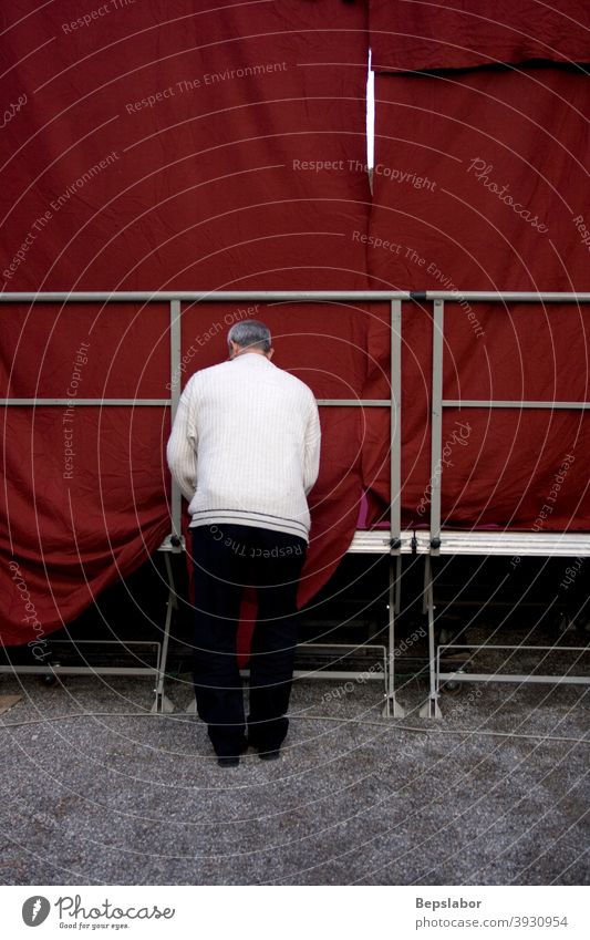 Mann arrangiert das rote Festzelt der Konferenzbühne Zelt Tagung Schauplatz Arbeiter Festakt arbeiten Menschen fixieren Pflege Perfektionist hinten