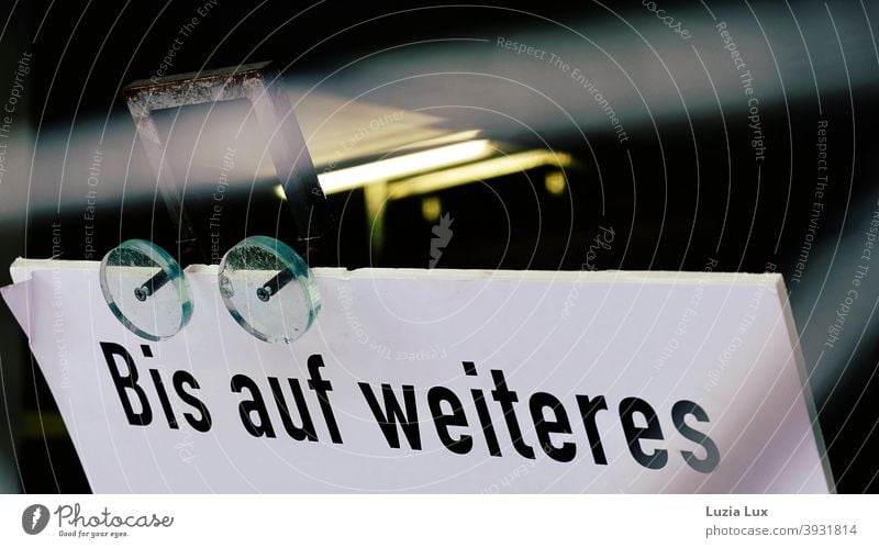 Bis auf Weiteres... Teilansicht eines Schildes, darüber Neonlicht Schilder & Markierungen geschlossen Schrift Licht Hinweisschild Buchstaben Menschenleer