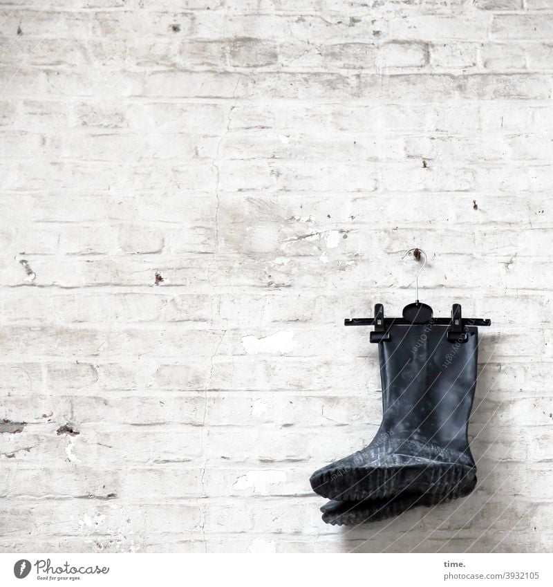 dutch wall style Stiefel Gummistiefel wand mauer hängen dekoration kleiderbügel trashig alt skurril Backsteinwand gestrichen abblättern schrauben haken schwarz