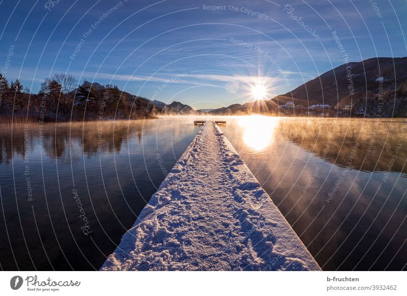 Langer Steg mit Schnee bedeckt bei Sonnenaufgang Nebel See Wasser Alpen Morgen ruhig Morgendämmerung Natur Landschaft Seeufer Umwelt Außenaufnahme Himmel Idylle