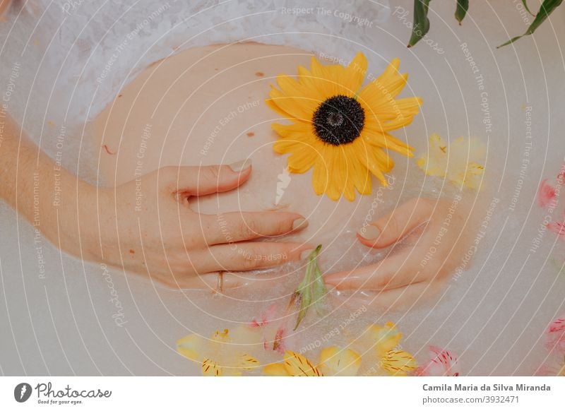 Schwangere Mädchen in einem Bad mit Milch und Blumen Unterstützung Badewanne schön Schönheit Bauch Körper Pflege Sauberkeit Damenhygiene Blumen in Milch melken