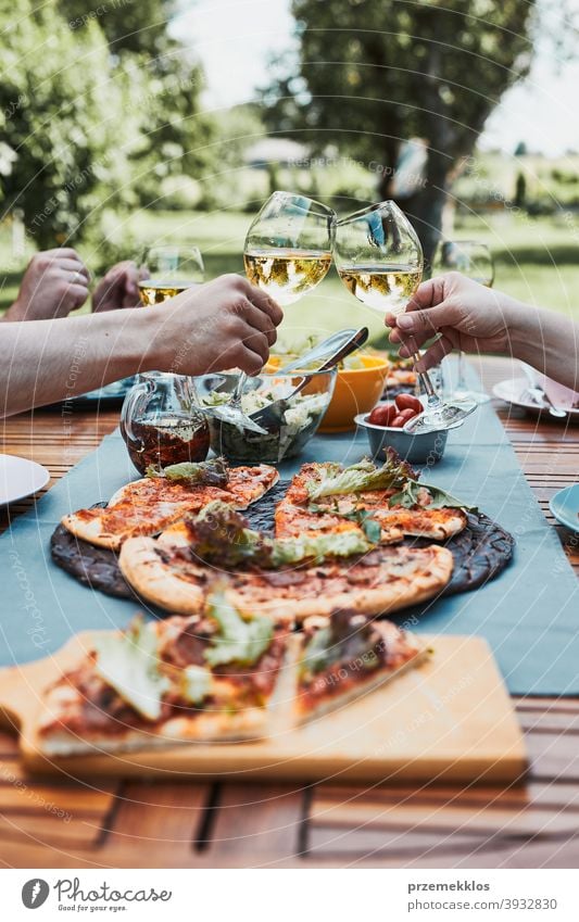 Freunde machen Toast während Sommer-Picknick im Freien Abendessen in einem Haus Garten Hinterhof Getränk Feier Speise trinken Essen Familie Festessen