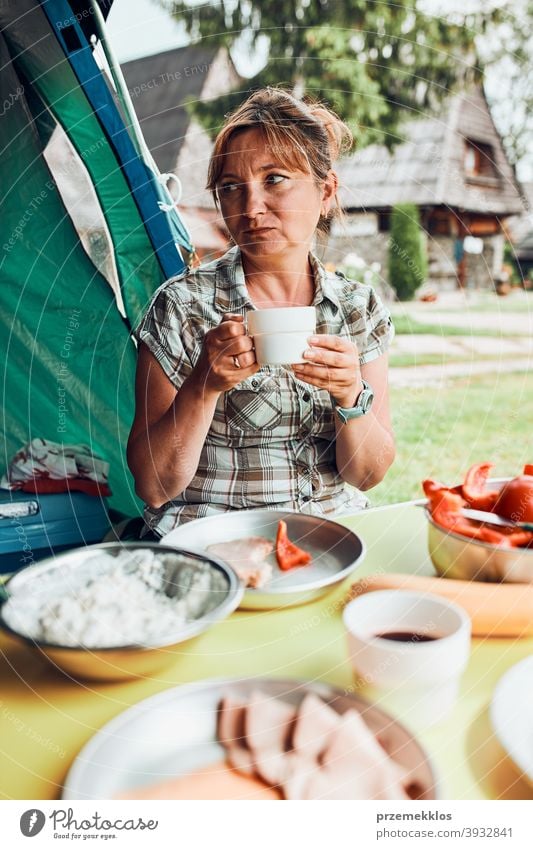 Familie beim Frühstück im Freien auf dem Campingplatz in den Sommerferien authentisch wirklich Banane gekochtes Fleisch langsames Leben Tischdecken im Freien