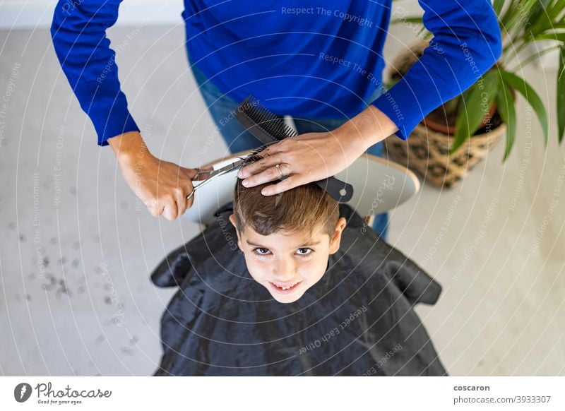 Lustiger Junge bekommt Haarschnitt zu Hause mit Schere bezaubernd Friseur Barbershop Schönheit Kaukasier Kind Kindheit schließen Kamm geschnitten niedlich Gerät