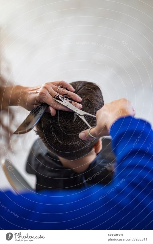 Lustiger Junge bekommt Haarschnitt zu Hause mit Schere bezaubernd Friseur Barbershop Schönheit Kaukasier Kind Kindheit schließen Kamm geschnitten niedlich Gerät