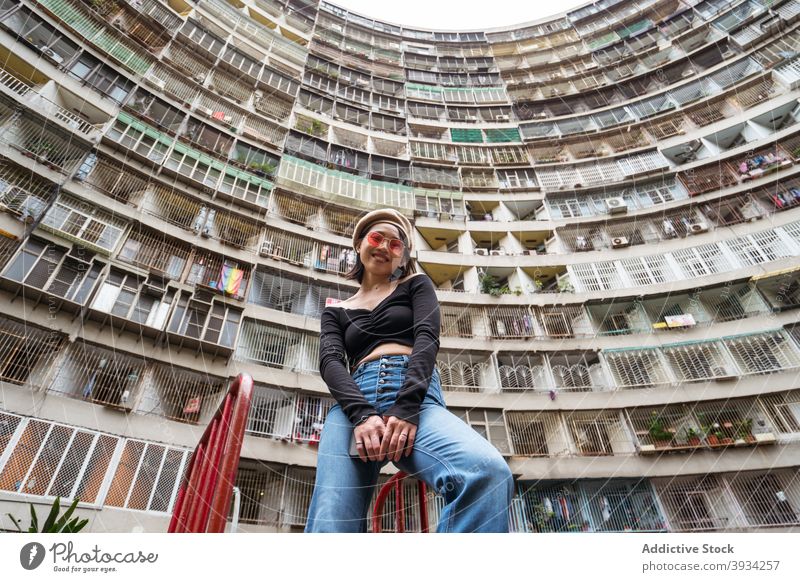 Frau stehend gegen hohe moderne Stadt Gebäude hoch wohnbedingt Architektur Kurve Fassade Wand mehrstöckig jung Straße Großstadt Taiwan kaohsiung urban