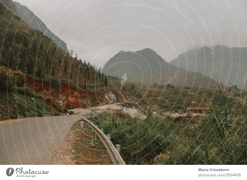 Filmische neblige kurvenreiche Straße zu den Karstbergen im Meo vac District, Ha giang Vietnam unesco Feiertag Ausflugsziel leere Straße nordvietnam Tourismus