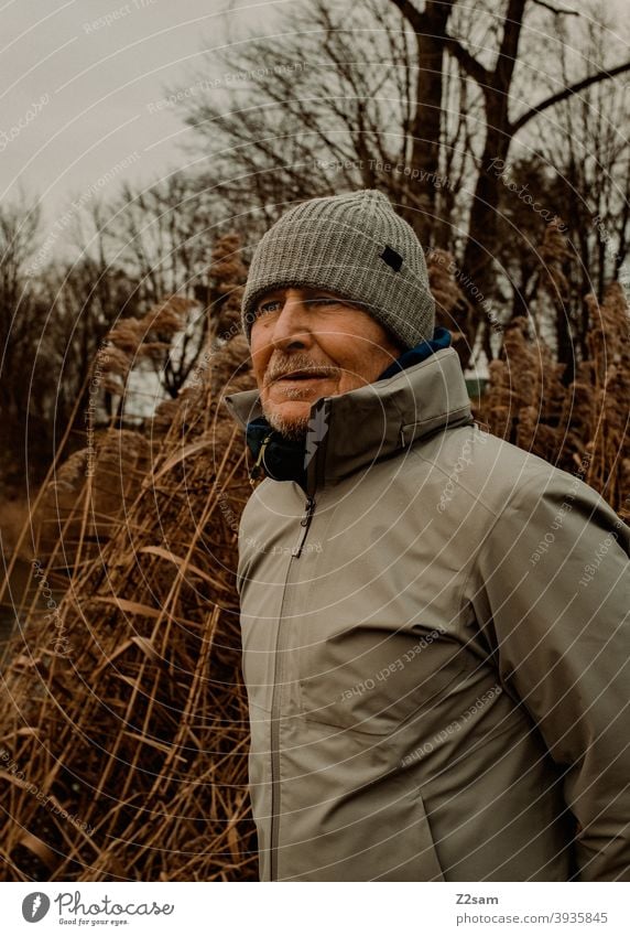 Portrait eines sportlichen Rentners in der Natur spazieren im Freien Sport rentner Ändern Mann Porträt mütze Winter Kälte Landschaft Wald sträucher freizeit