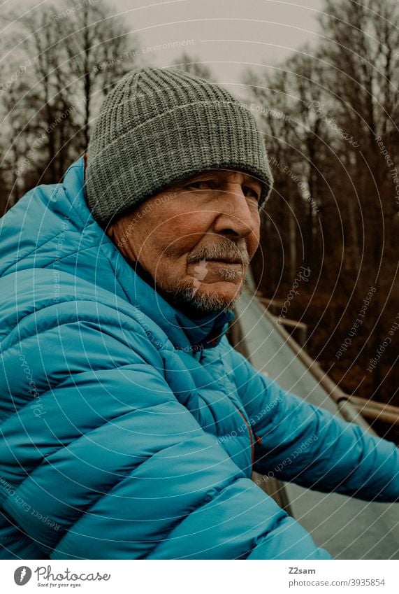 Skeptischer Blick eines sportlichen Rentners in der Natur spazieren im Freien Sport rentner Ändern Mann Porträt mütze Winter Kälte Landschaft Wald sträucher