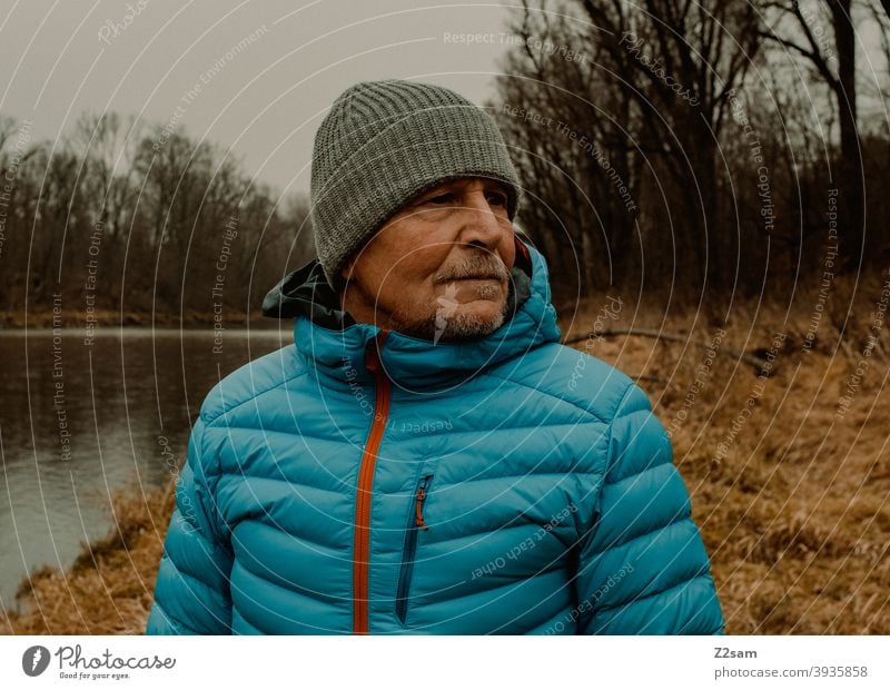 Portrait eines sportlichen Rentners in der Natur spazieren im Freien Sport rentner Ändern Mann Porträt mütze Winter Kälte Landschaft Wald sträucher Isar