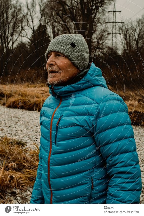 Portrait eines sportlichen Rentners in der Natur spazieren im Freien Sport rentner Ändern Mann Porträt mütze Winter Kälte Landschaft Wald sträucher Isar