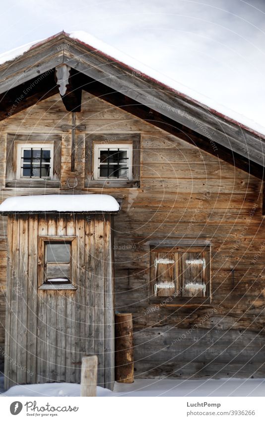 Holzhaus mit Schnee Hütte Farbfoto Außenaufnahme Winter kalt Tag Menschenleer Frost Winterurlaub Haus Hüttengaudi Holzbrett Holzhütte Fenster Fensterladen Dach