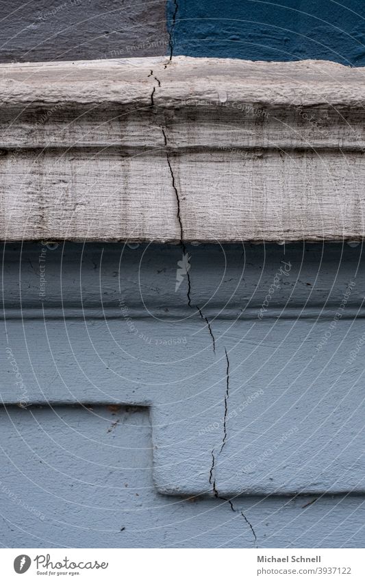 Riss in der Fassade mit verschiedenen Blautönen Hauswand Wand Mauer Außenaufnahme Menschenleer Farbfoto Gebäude trist Architektur alt Rissbildung Differenzen