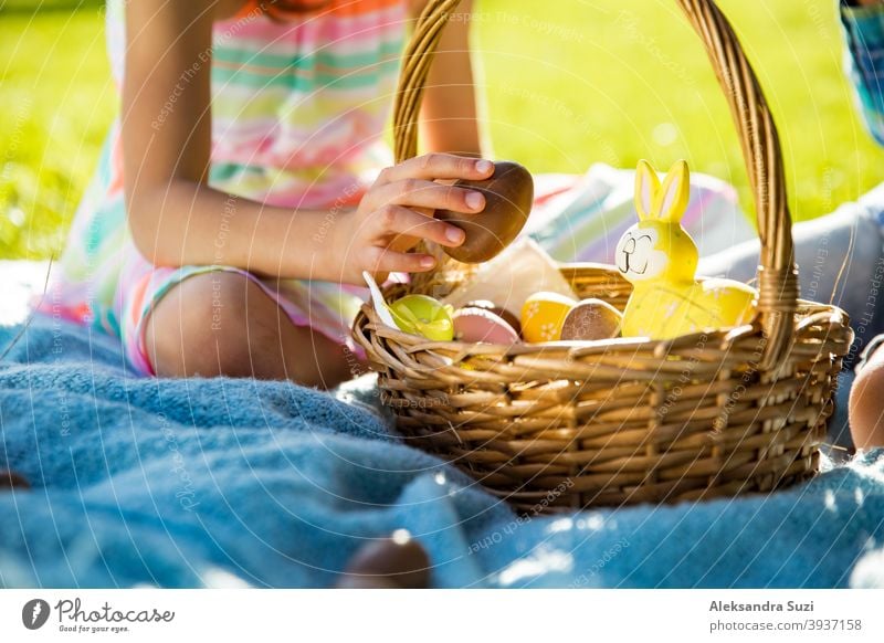 Netter Junge und Mädchen feiern Ostern, suchen und essen Schokoladeneier. Glückliche Familie Urlaub. Glückliche Kinder lachen, lächeln und Spaß haben. Schöner Frühling sonnigen Tag im Park