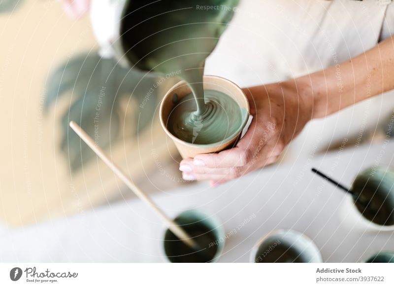 Frau mischen Farben für die Erstellung von Gemälde an der Wand Künstler Anstreicher heimwärts Pigment eingießen Fensterblätter Blatt Mundschutz behüten Tasse