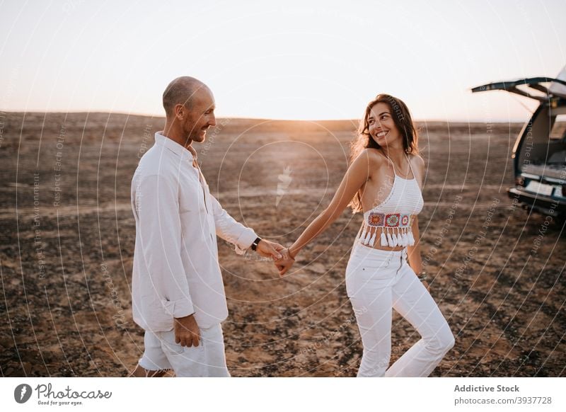 Unbekümmertes reisendes Paar hält Hände in der Savanne Händchenhalten Sonnenuntergang Liebe Sommer Urlaub Zusammensein Partnerschaft Abend Freundin Spaziergang