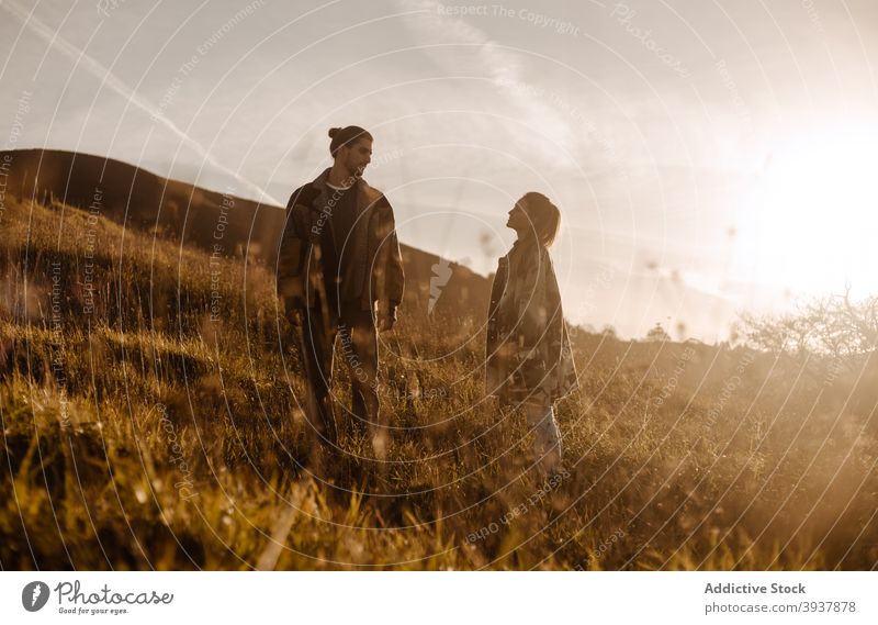 Paar steht zusammen im Feld bei Sonnenuntergang Zusammensein Liebe retro Outfit Stil altehrwürdig Zuneigung Abend Glück Partnerschaft jung romantisch Angebot