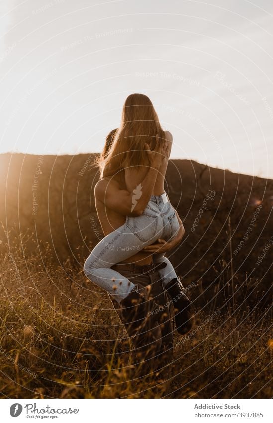 Paar mit nackten Torsos umarmen im Feld nackter Torso Umarmung Umarmen Sonnenuntergang Zusammensein Liebe heben Partnerschaft Freund oben ohne Vorspiel Freundin