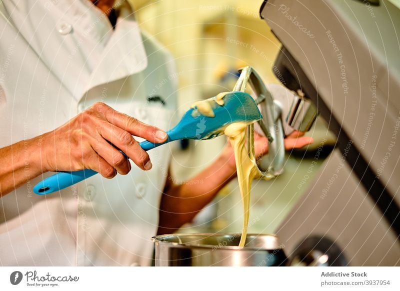 Bäcker bei der Herstellung von Teig in einer professionellen Knetmaschine Frau Gebäck Bäckerei Teigwaren Mixer Konditorei Rührbesen vorbereiten Spachtel Küche