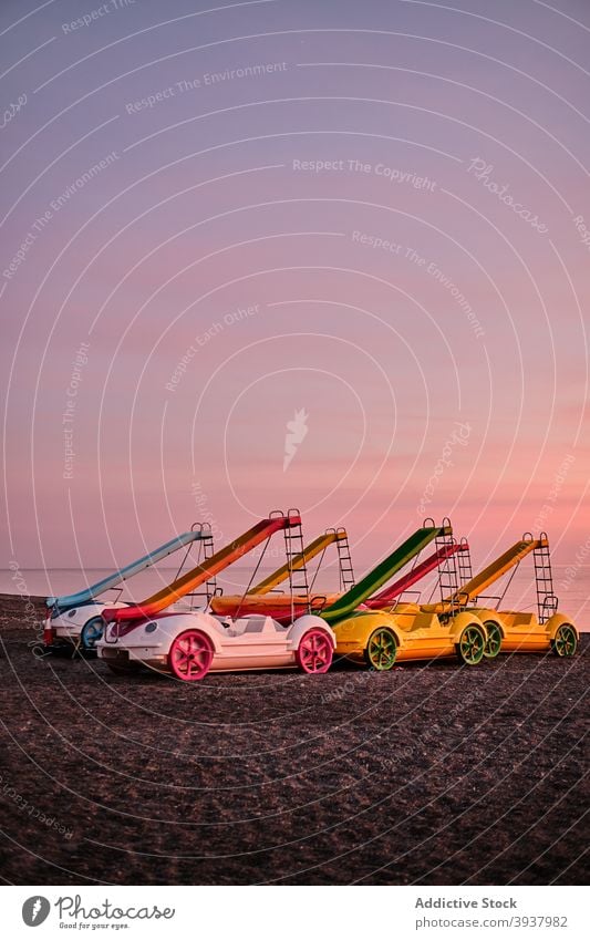 Bunte Tretboote mit Rutschen am Strand in der Nähe von Meer Pedal Boot Sliden MEER Sonnenuntergang Küste Ufer Sand Spanien Sammlung farbenfroh Abenddämmerung