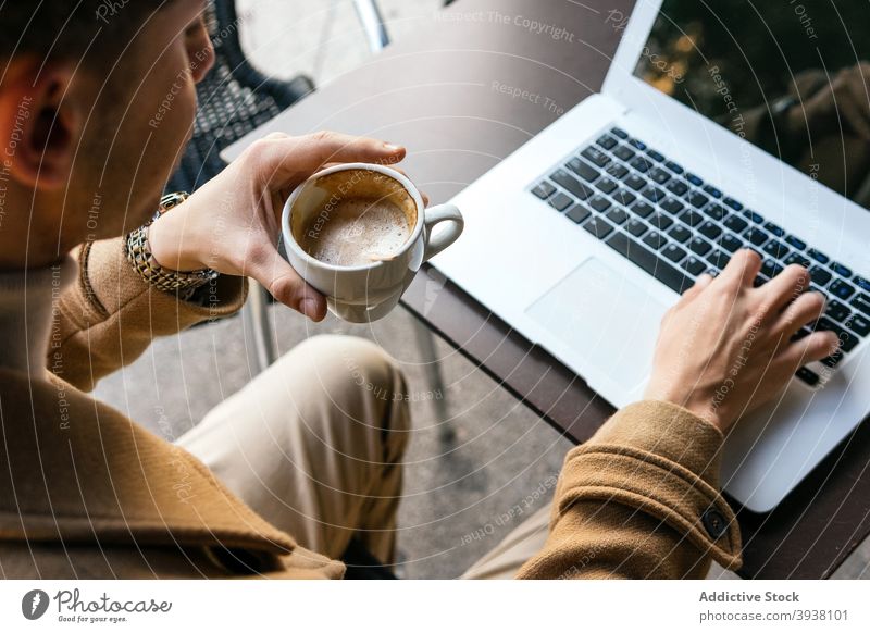 Crop Mann Tippen auf Laptop im Café Geschäftsmann Kaffee Tasse Arbeit abgelegen Projekt Unternehmer männlich Browsen Apparatur Gerät Internet benutzend Netbook