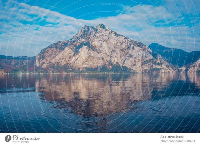 Rippling See umgeben von felsigen Bergen gegen bewölkten blauen Himmel Berge u. Gebirge Ufer Landschaft Natur Ambitus Hochland Seeufer Reflexion & Spiegelung