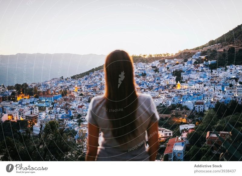 Anonyme Dame genießt den Blick auf die Stadt am Hang des grünen Hügels Frau bewundern Stadtbild Berghang Tourist Sightseeing Aussichtspunkt Großstadt