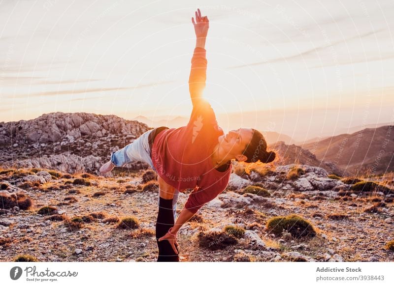 Crop anonyme Person Unterstützung konzentriert Frau Durchführung Natarajasana Yoga-Pose in den Bergen Herr des Tanzes Zusammensein Gleichgewicht Wellness