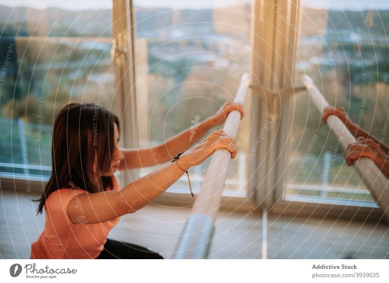 Frau macht Pilates-Übungen in der Nähe von Barre Stange Training schlank Dehnung üben Fokus Gesundheit Sportbekleidung physisch Ausdauer Energie anstrengen