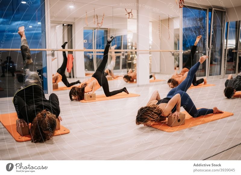 Gruppe von Menschen tun Yoga in Downward Facing Dog Pose im Studio Klasse üben Menschengruppe nach unten gerichtete Hundehaltung Gleichgewicht Atelier Asana