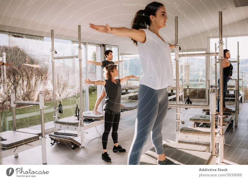 Menschen machen Yoga auf Pilates-Reformern mit Lehrer Klasse Menschengruppe üben Zusammensein fünfzackige Stern-Pose Trainerin Sportkleidung Sportbekleidung