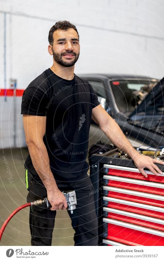 Beschäftigter Mechaniker mit Werkzeugschrank in Autowerkstatt Kabinett Mann Techniker PKW Dienst Instrument Arbeit Station männlich Job Garage Flugzeugwartung