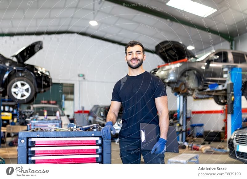 Beschäftigter Mechaniker mit Werkzeugschrank in Autowerkstatt Kabinett Mann Techniker PKW Dienst Instrument Arbeit Station männlich Job Garage Flugzeugwartung