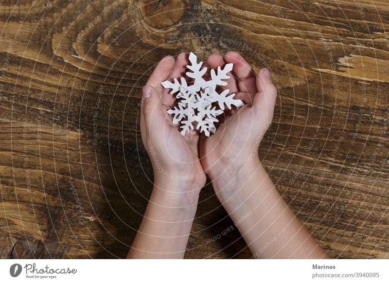 Kind hält eine hölzerne Schneeflocke. jung lustig Fröhlichkeit Schneefall Winter Lifestyle Studioaufnahme Hintergrund Halt Weihnachten Dekoration & Verzierung