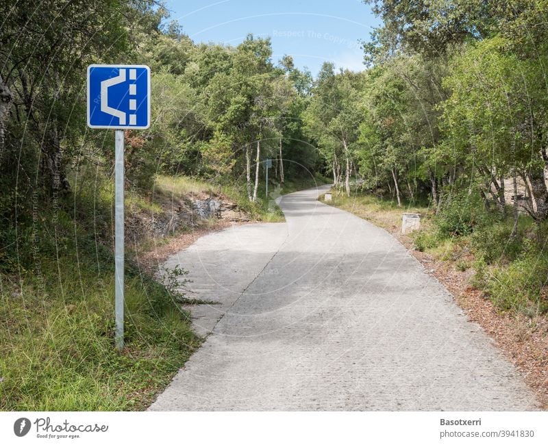 Ausweichstelle auf einer schmalen Strasse im Wald Schild Verkehrsschild Zeichen Symbol blau weiß Straße eng Stelle Landstraße Berg Gebirge passstraße Sommer