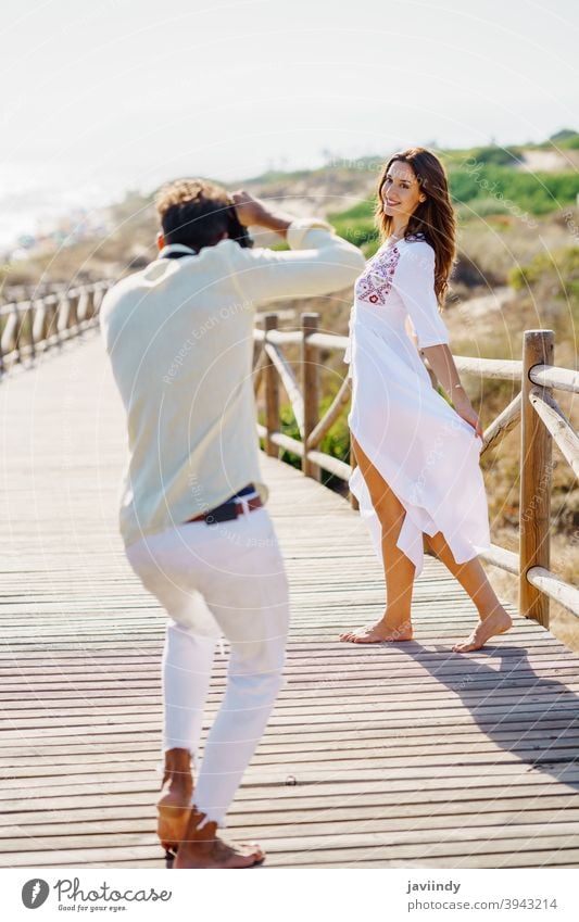 Mann, der seine Freundin bei einem Liebesausflug fotografiert. Paar Urlaub Fotograf Fotografieren Frau Reisender Tourist Resort Menschen Natur Freizeit Sommer