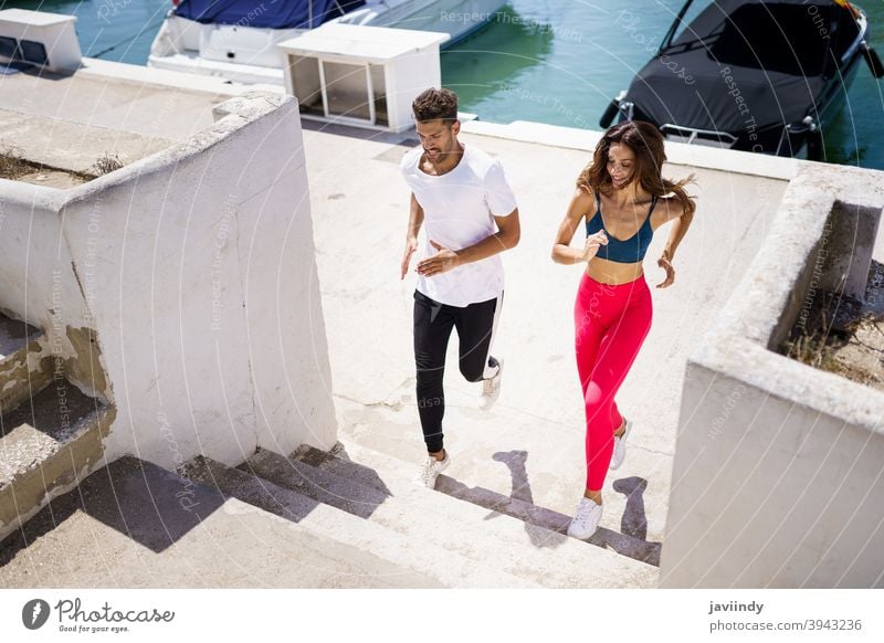 Sportliches Paar trainiert hart, indem es gemeinsam im Freien Treppen hochläuft. rennen Fitness Schritt Training Frau Mann Mädchen passen Aktivität jung