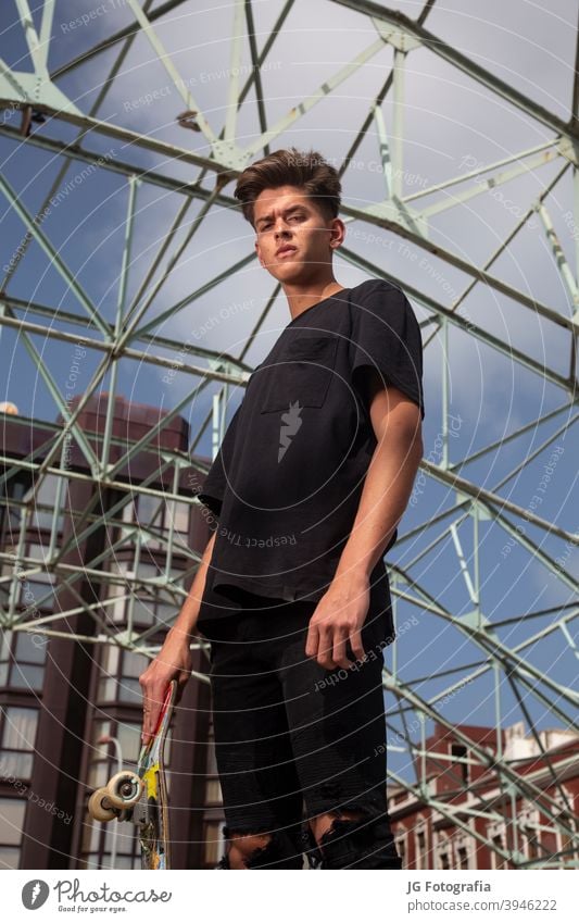 Porträt der jungen Skateboarder mit schwarzem T-Shirt und Straße und blauem Himmel Hintergrund. Aussehen sitzen Skateboarderin Lifestyle Erholung allein Schuh