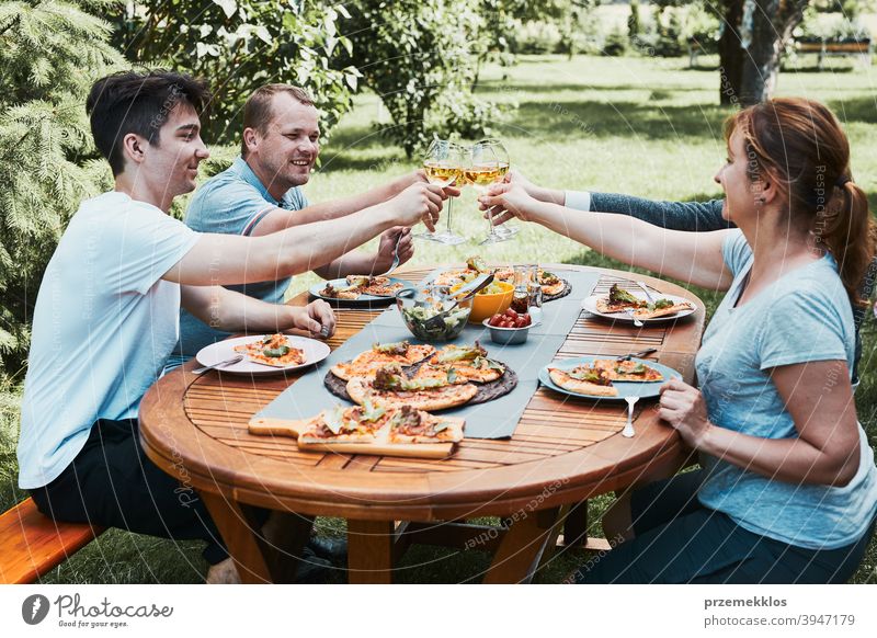 Freunde machen Toast während Sommer-Picknick im Freien Abendessen in einem Haus Garten Hinterhof Getränk Feier Speise trinken Essen Familie Festessen