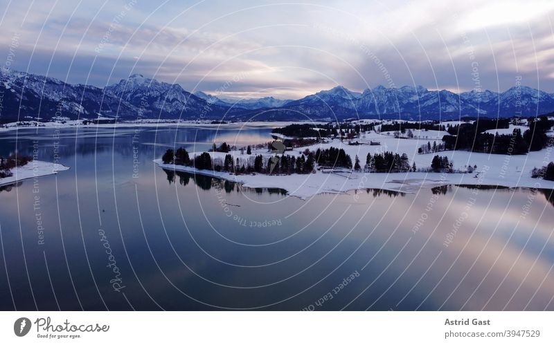 Luftaufnahme mit einer Drohne vom Forggensee im Allgäu im Winter in der blauen Stunde luftaufnahme drohnenfoto forggensee gewässer bayern allgäu stausee winter