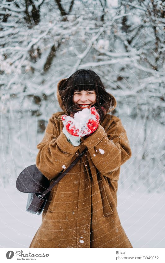 Schneeverliebt im Winter - Eine junge Frau steht im Schnee und lacht vor Freude lachen winterlich brünett Lebensfreude Schneelandschaft verschneit spielen