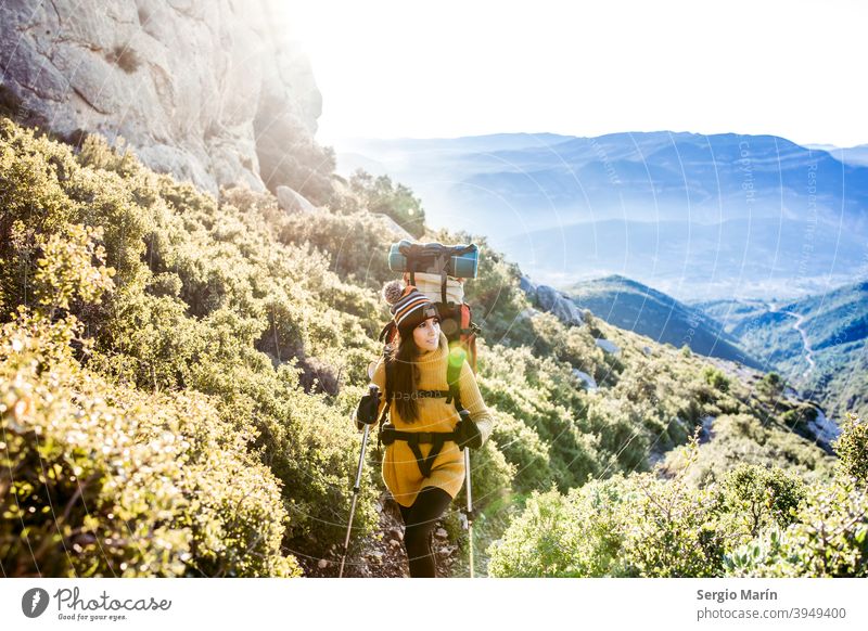 Happy Wandern Mädchen mit einem Rucksack steigt einen Bergpfad. Reisen Lifestyle-Konzept. Expedition Frau Camping Abenteuer Glück Trekking Entdecker im Freien