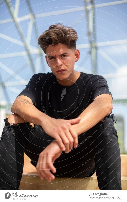 Porträt der jungen Skateboarder mit schwarzem T-Shirt und Straße und blauem Himmel Hintergrund. Aussehen sitzen Skateboarderin Lifestyle Erholung allein Schuh