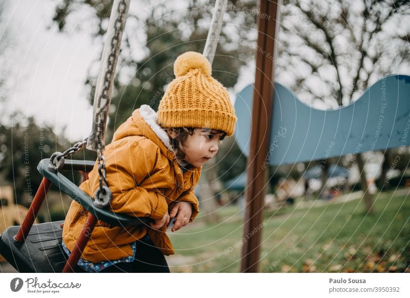 Kind spielt auf dem Spielplatz Spielplatzgeräte Sliden Winter Herbst orange Kinderspiel Kindheit Kindergarten Freizeit & Hobby Kleinkind Mensch Spielen Freude