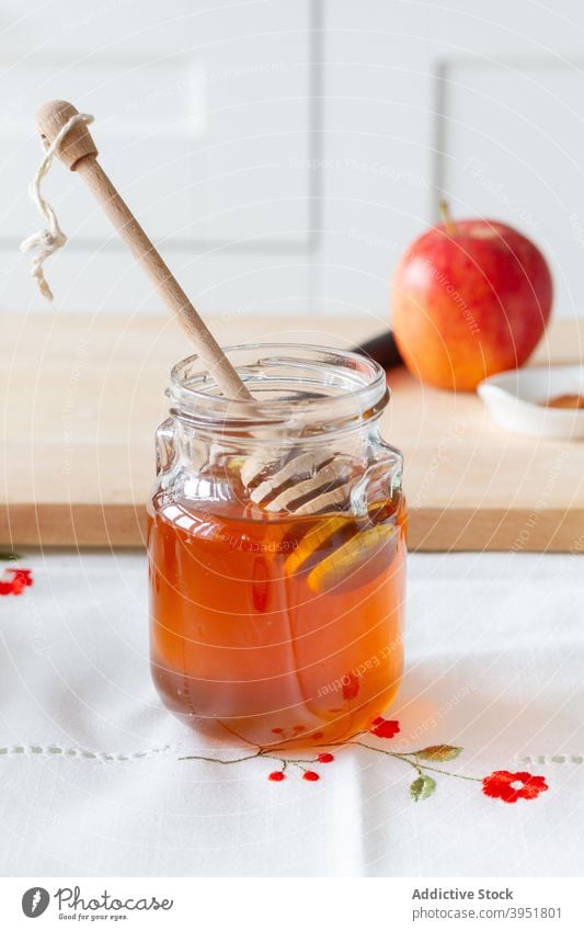 Glas Honig in der Nähe von Brett mit Apfel Liebling Tisch Küche heimwärts Koch Löffel Schneidebrett Dessert süß Bestandteil Snack reif lecker Lebensmittel