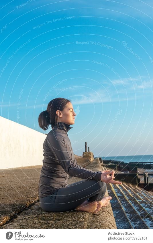 Sorglose Frau macht Yoga in Lotus-Pose meditieren Asana Harmonie friedlich sich[Akk] entspannen padmasana Stein Mudra sonnig Gesundheit Zen Augen geschlossen